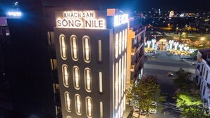 A building with illuminated windows and a sign reading "KHÁCH SAN SŰNG NILE". - Nile Hotel Phu Yen  (Tuy Hoa)