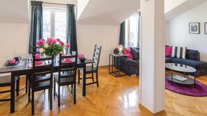 Ein modernes Wohnzimmer mit Essbereich, Holzboden und einer Sofagarnitur.