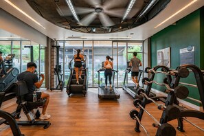 Ein Fitnessstudio mit Laufbändern, Crosstrainern und Gewichten.