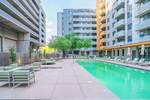 A modern outdoor pool area with lounge chairs and a clear pool. - Urban Oasis in DT Phoenix  w Pool, Gym and Parking (Phoenix)