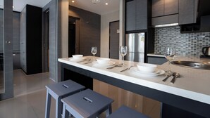 A modern kitchen with a central island, stainless steel appliances, and pendant lighting. - Citygate 2 BR Pool View P503-4 (Kamala)