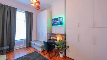 Een moderne kamer met een bureau, stoel en een wandgemonteerde televisie met een thuisscherm.