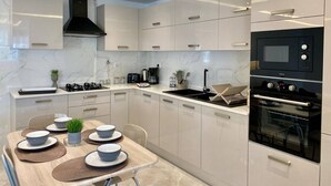 Eine moderne Küche mit weißen Schränken, einem schwarzen Herd und einem eingebauten Backofen.