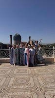 Un grupo de personas en una terraza en la azotea con piso estampado y una estructura en forma de cúpula al fondo.