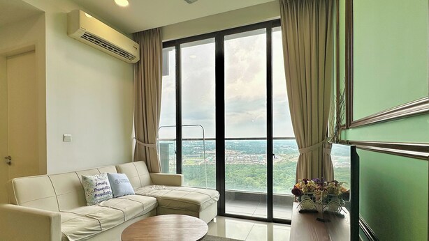 A modern living room with a sofa, a coffee table, and a view of a cityscape through large windows. - D'Pristine Medini by Stayrene (Iskandar Puteri)