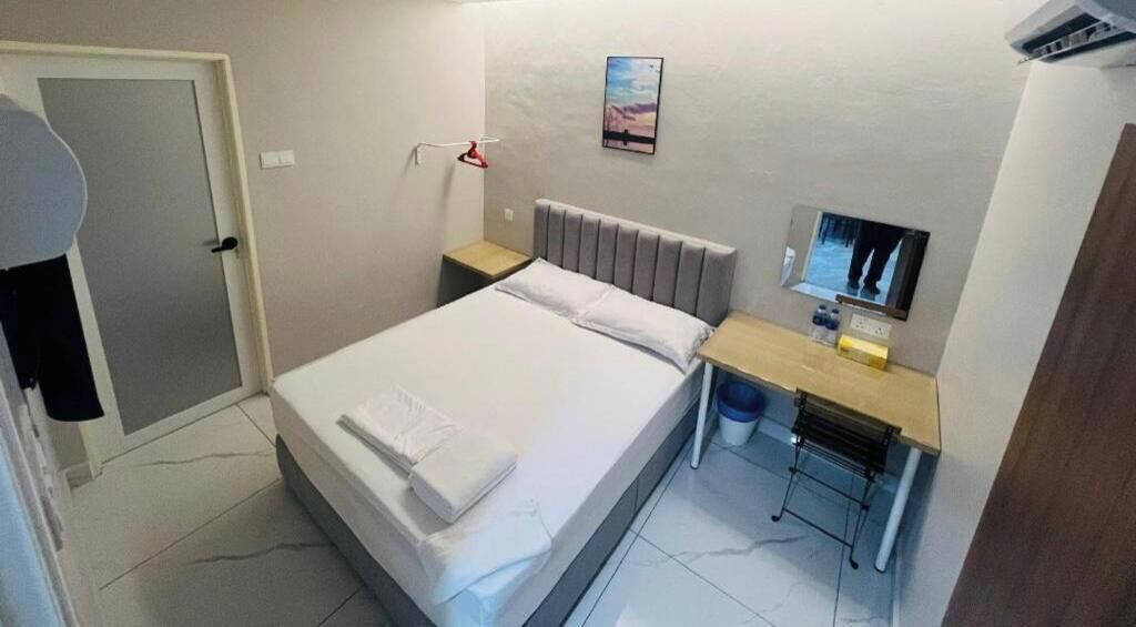 Ein Schlafzimmer mit einem Bett, einem Schreibtisch, einem Stuhl, einem Spiegel und einer Tür.