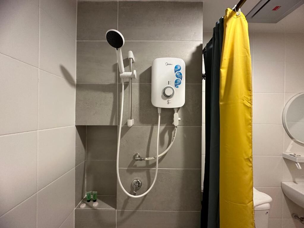 A bathroom with a shower, a toilet, and a sink.