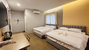 Une chambre d’hôtel avec deux lits, un bureau avec une bouilloire et un appareil de climatisation.
