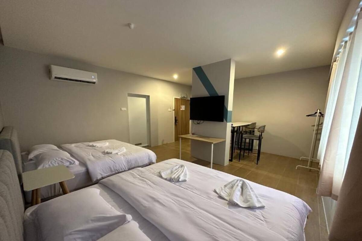 Ett hotellrum med två sängar, en TV, ett skrivbord och en stol.
