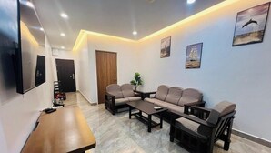 Una sala de estar moderna con un juego de sofá, una mesa de centro y un televisor montado en la pared.