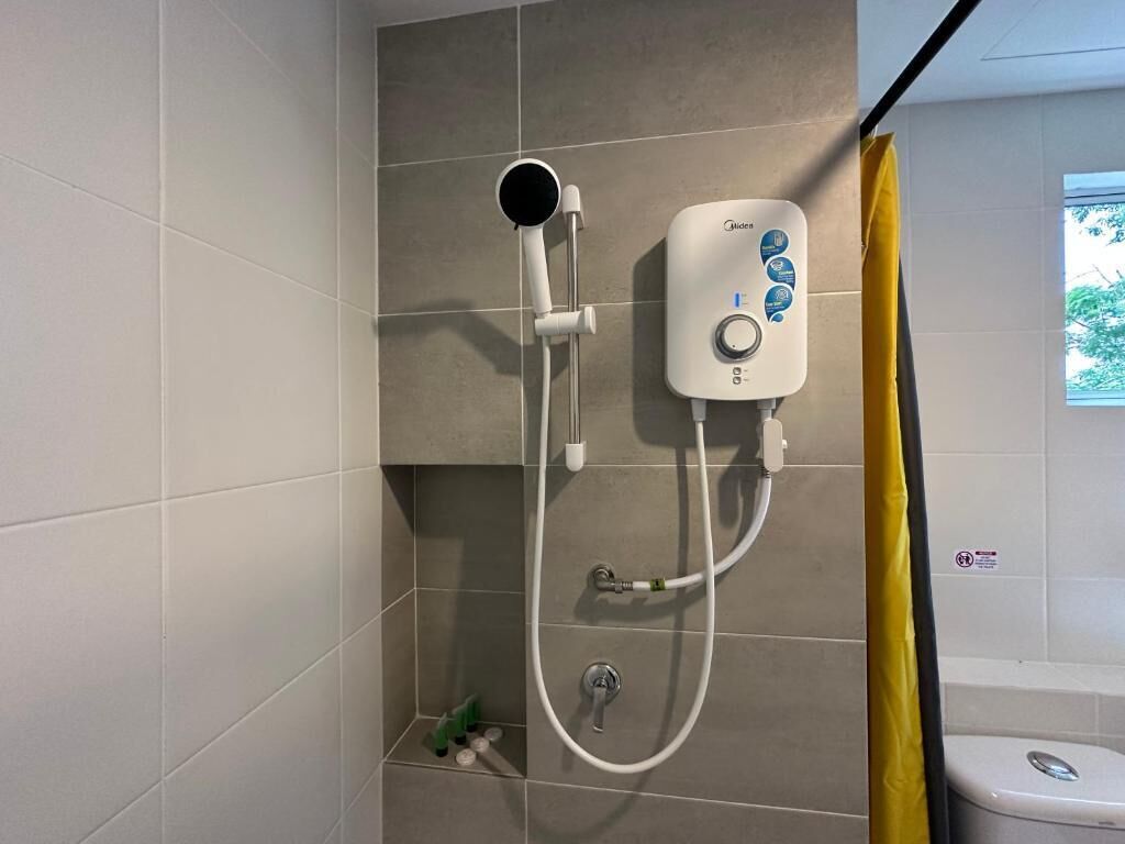 Un baño con ducha, panel de control y retrete.