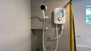 Un baño con ducha, panel de control y retrete.