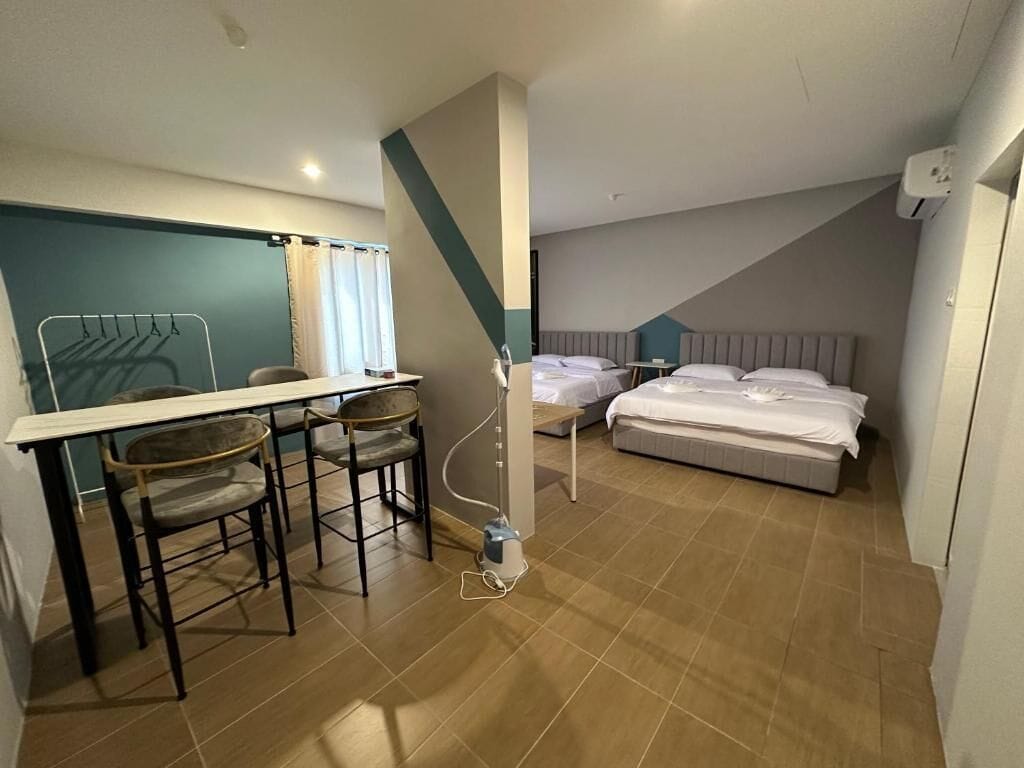 A compact hotel room with a dining area, a bed, and a small table.