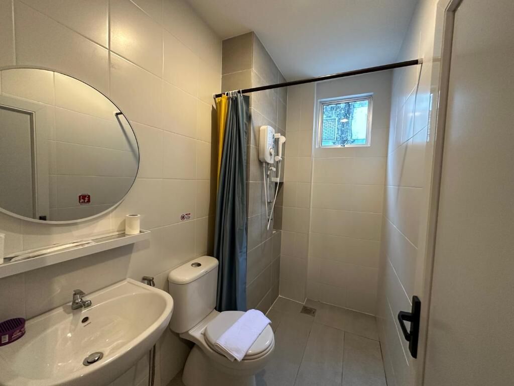 A compact bathroom with a sink, toilet, and shower.