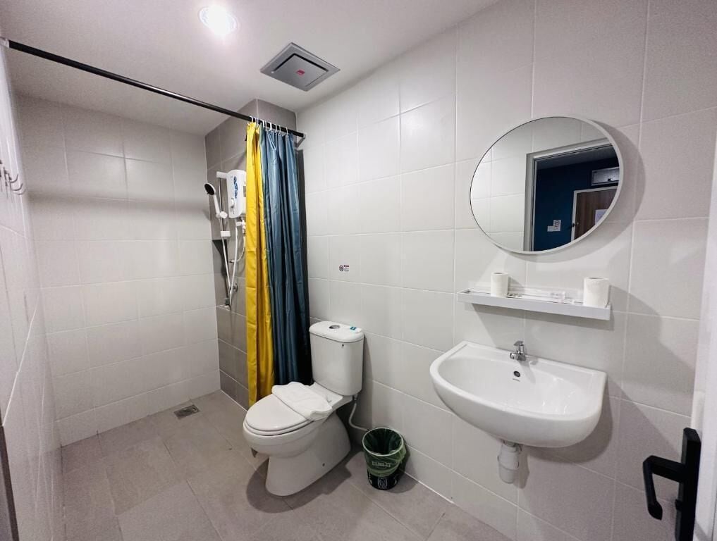 Une salle de bain moderne équipée de toilettes, d’une douche et d’un lavabo.
