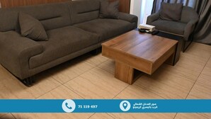 Una sala de estar moderna con un sofá, un sillón y una mesita de centro.