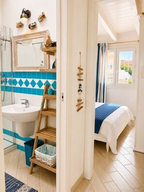 Un bagno con lavandino, specchio e doccia.