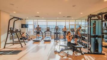 A gym with treadmills, weight machines, and free weights.