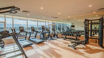 A gym with treadmills, stationary bikes, and weightlifting equipment.