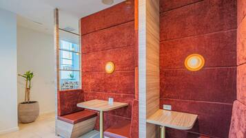 A modern interior with red walls, a wooden bench, and a small table.