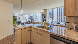 A modern kitchen with a large island, stainless steel appliances, and pendant lighting. - Downtown PHX Retreat Pool, Gym Balcony Views (Phoenix)