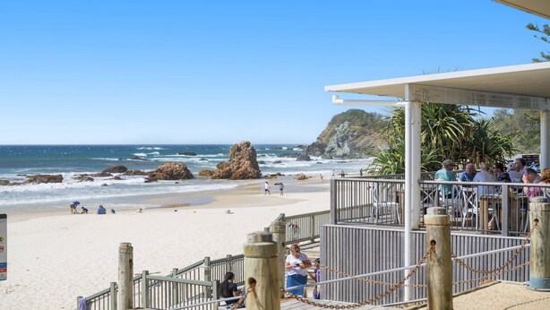 A beachside restaurant with outdoor seating overlooking the ocean, featuring a wooden deck and metal railings. - Flynns Beach Seascape (Port Macquarie)
