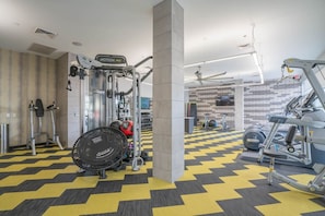 A gym with various exercise equipment, including treadmills, weight machines, and a stationary bike. - Modern ASU Apt | Roosevelt Row | W/D + FreeParking (Phoenix)
