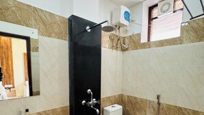 A bathroom with a sink, toilet, and shower. - CITY GRAND (Puri)