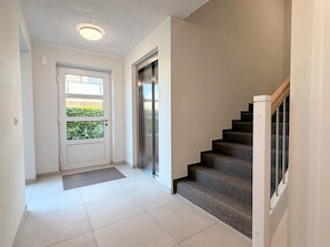 A hallway with a door, a doormat, a staircase, and a wall-mounted elevator. - 2150 Gode Ström Quartiere "Fief" - Beach meadow - 2150 - Gode Ström Quartiere (Dahme)
