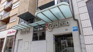 A hotel named 'Cardena' with a modern facade, large glass windows, and a visible fire hydrant.