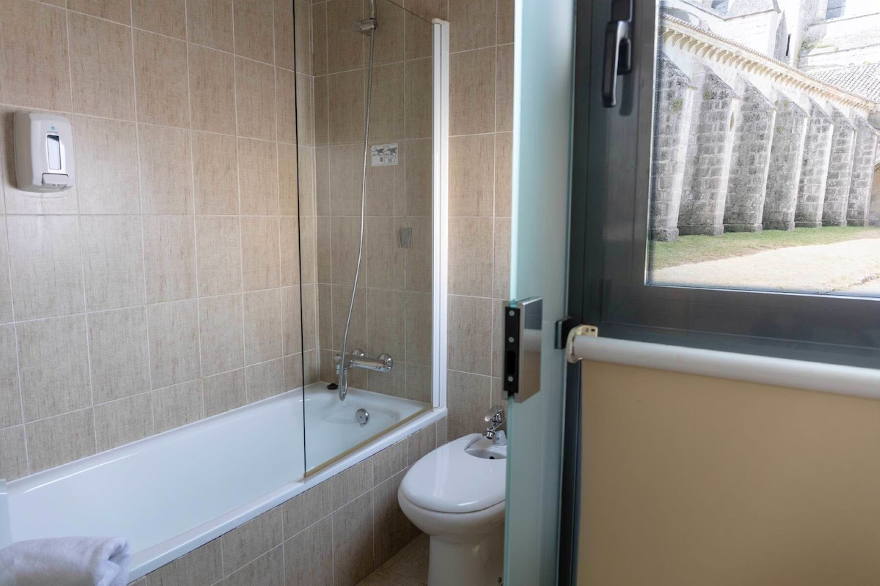Un baño con ducha envuelta en vidrio, bañera y retrete.