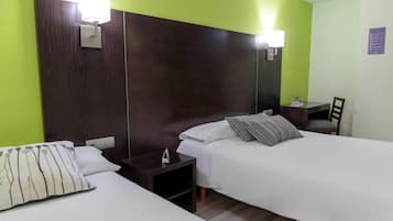 Una habitación de hotel con dos camas, una mesita de noche, un escritorio y una silla.