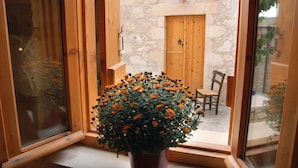 Ein Fenster mit Holzrahmen und einem Topf mit orangefarbenen Blüten.