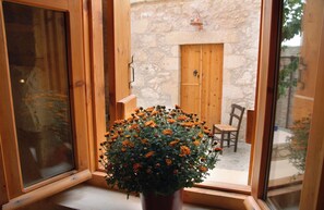 Ein Fenster mit Holzrahmen und einem Topf mit orangefarbenen Blüten.