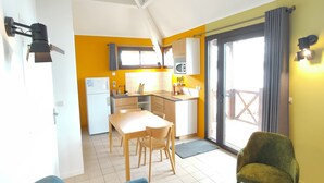 A compact living space with a kitchenette, a dining area, and a balcony with a view. - ACTIVITAL - Les Settons (Montsauche-les-Settons)