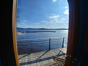 A wooden deck with a bench, overlooking a calm lake with a dock and distant hills. - ACTIVITAL - Les Settons (Montsauche-les-Settons)
