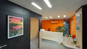 A reception area with a wooden desk, a plant, and a sign that reads "Actival".