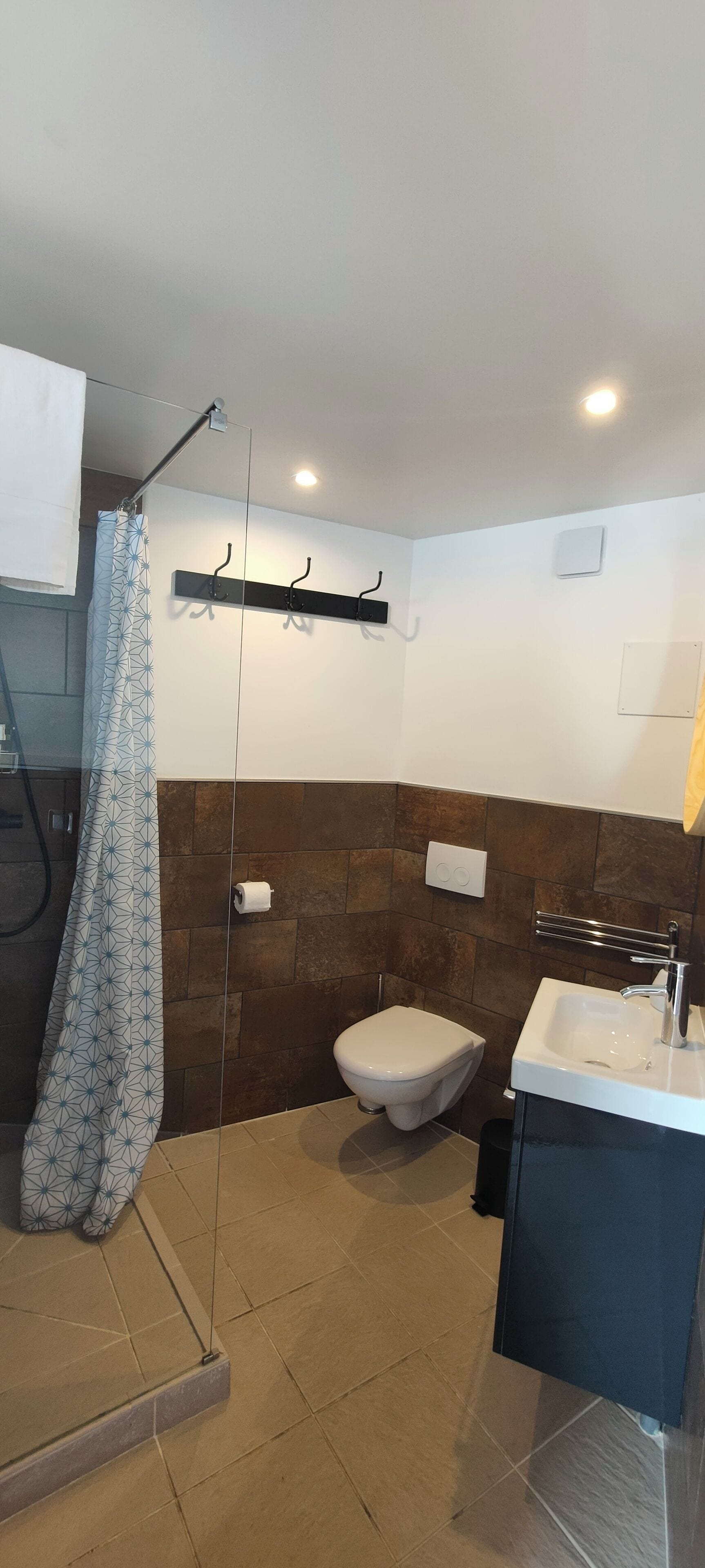 A bathroom with a shower, toilet, and sink.