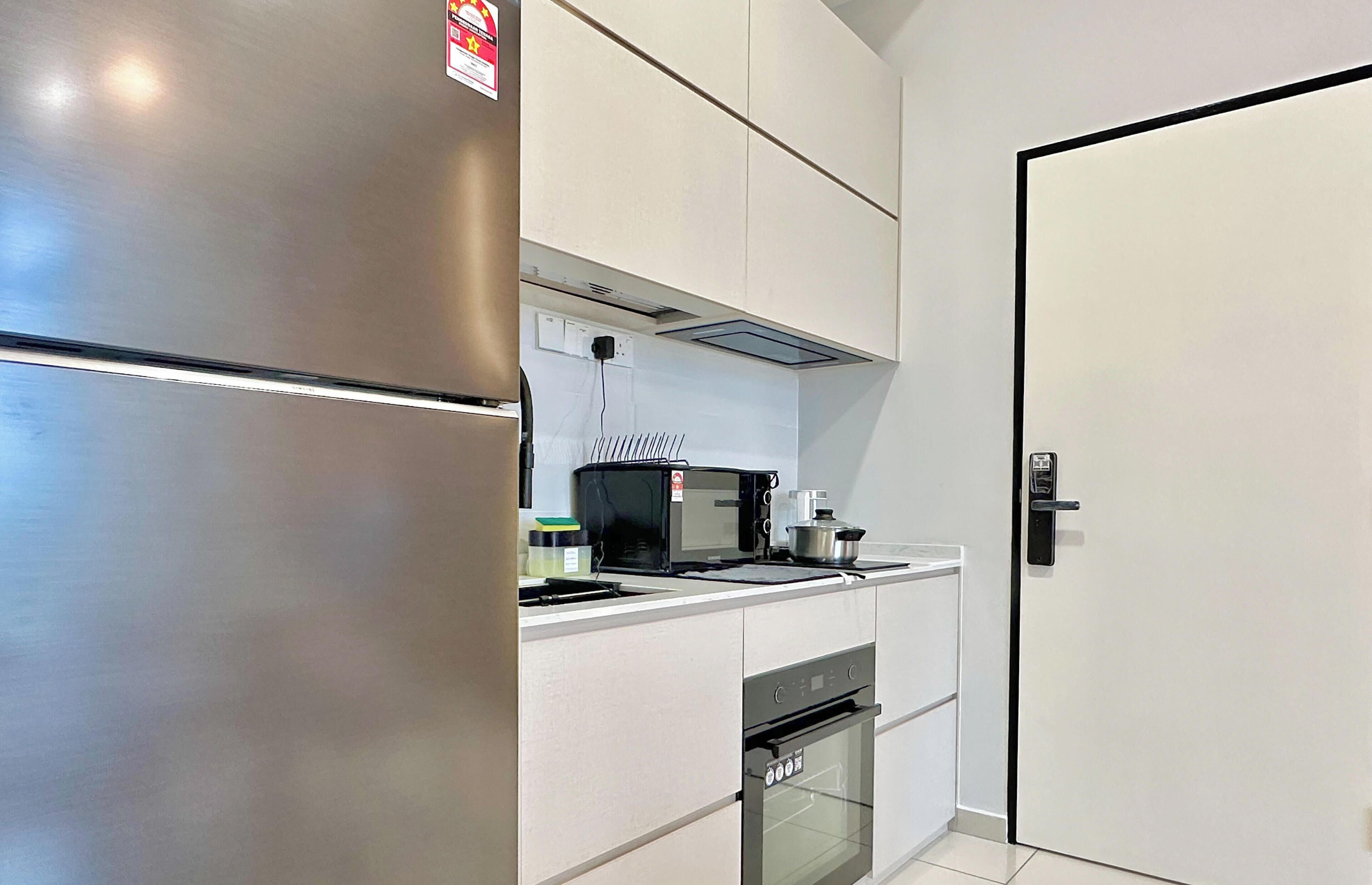 A modern kitchen with a stainless steel refrigerator, a microwave, and an oven.