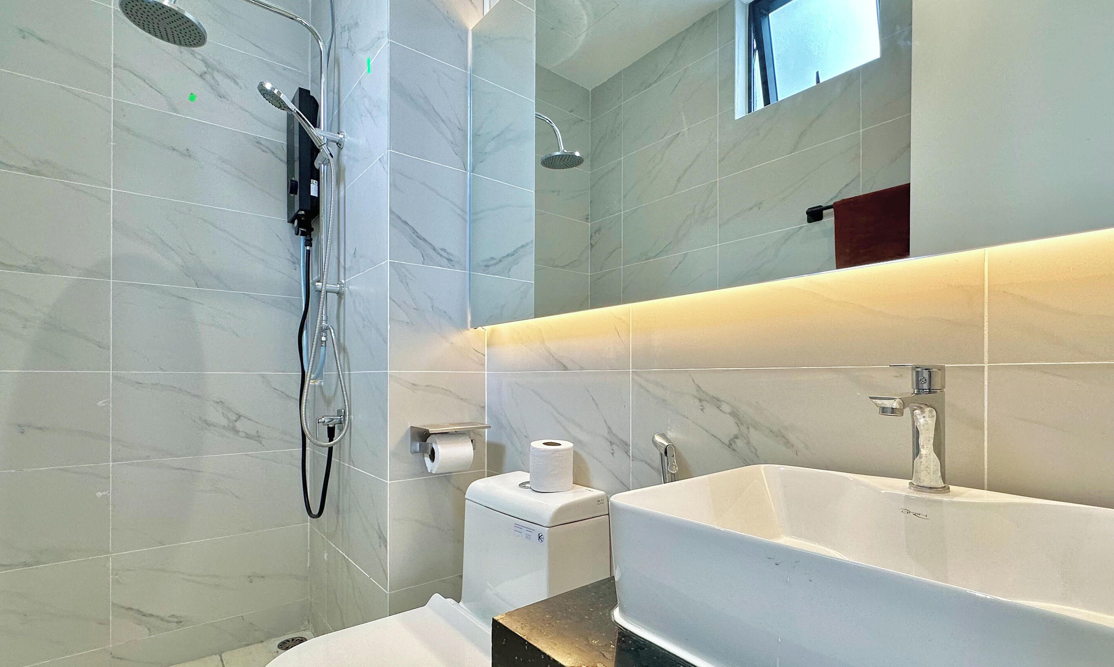 Un baño moderno con ducha, inodoro y lavamanos.