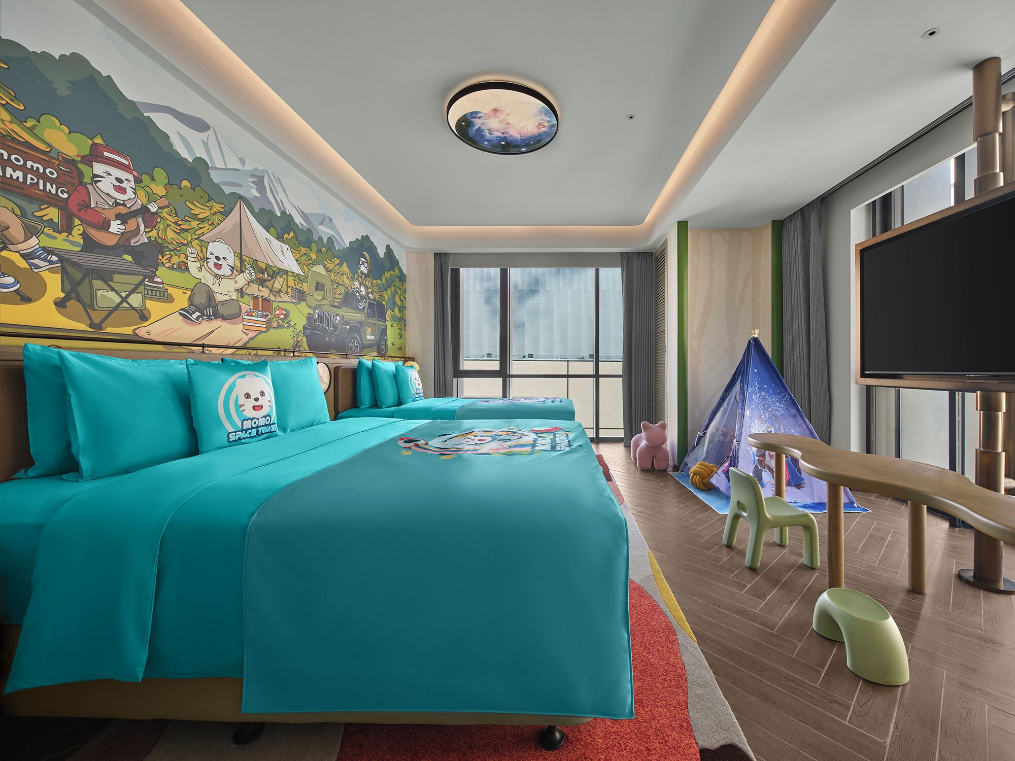 Une chambre d’hôtel avec un grand lit, une télévision, une fresque murale et une vue sur la ville.
