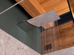 A shower with a wooden ceiling and a marble floor.