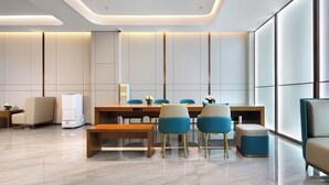 A modern dining area with a long table, blue and beige chairs, and a bench. - Jinglai Zhenxuan Shanghai Tongji Hospital Xincun Road Subway Station Hotel (Shanghai)