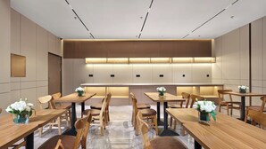 A modern conference room with wooden tables and chairs, a central raised platform, and recessed lighting. - Jinglai Zhenxuan Shanghai Tongji Hospital Xincun Road Subway Station Hotel (Shanghai)