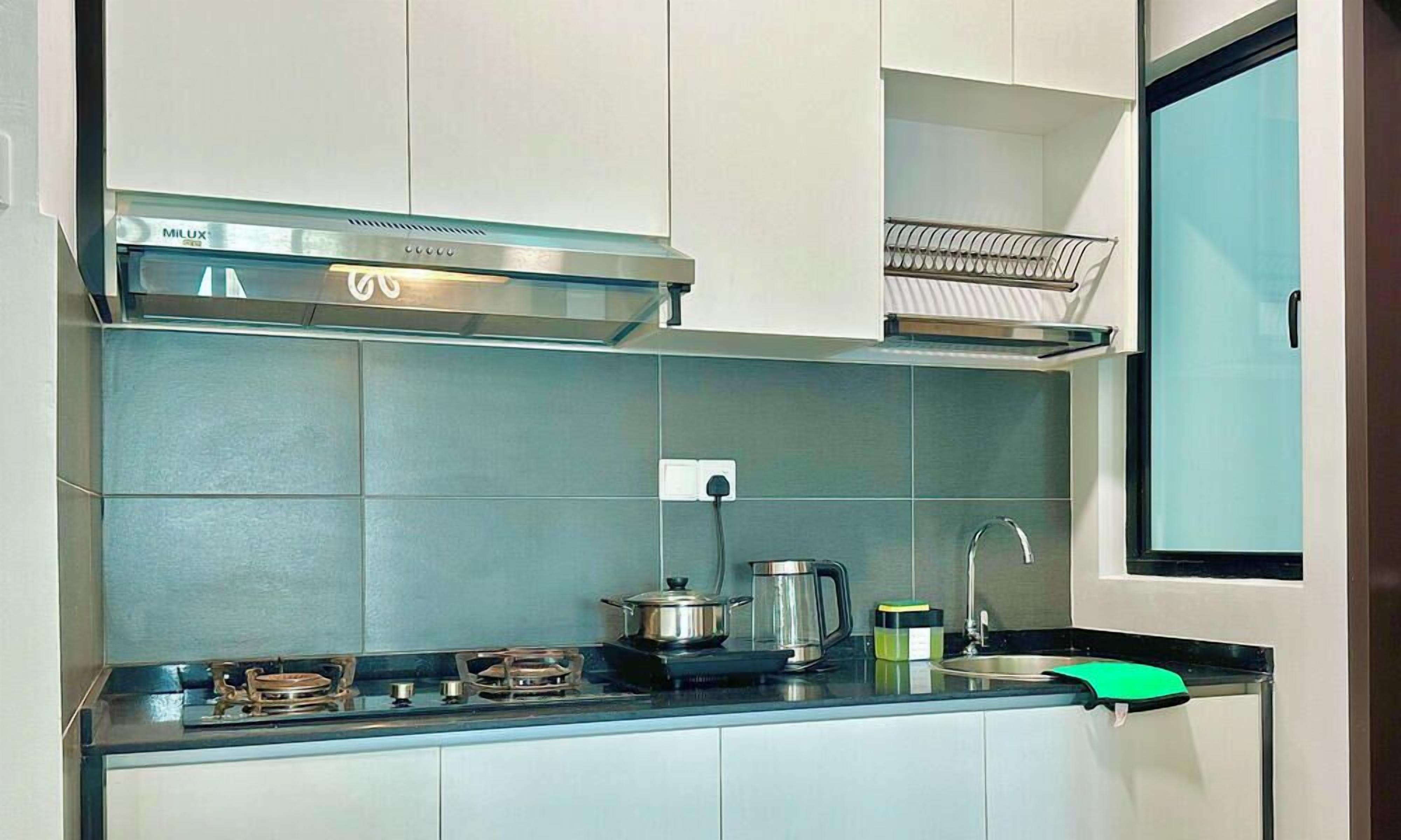 Une cuisine moderne équipée d’une cuisinière à gaz, d’une hotte en acier inoxydable et d’un four encastré.