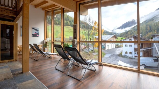 Amplia habitación con ventanas grandes que ofrecen vistas a un paisaje montañoso.