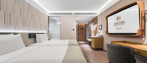 A modern hotel room with a large bed, a desk, and a large mirror.