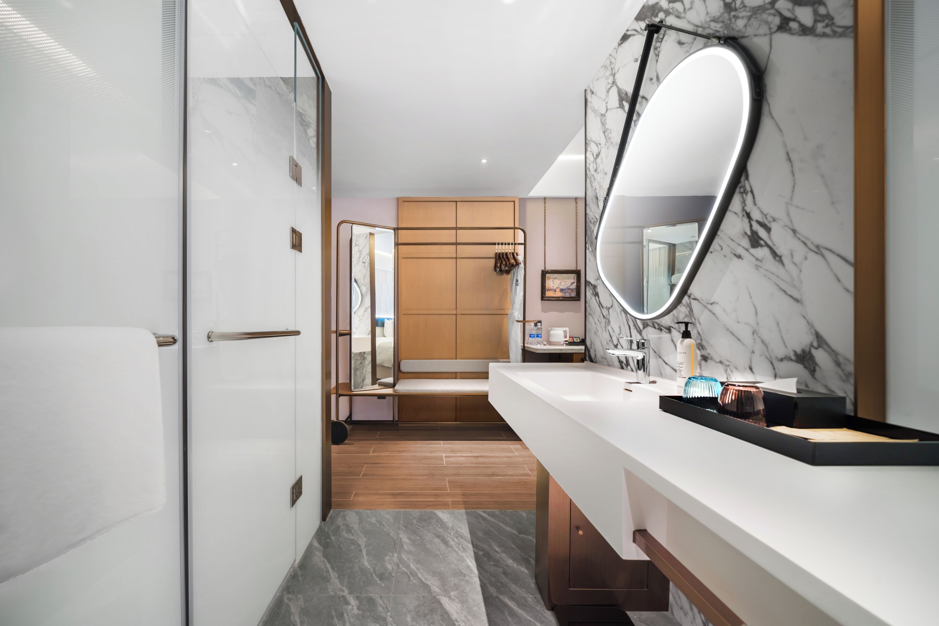 A modern bathroom with a large mirror, a vanity, and a shower area.
