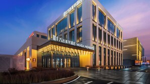 A modern hotel with a prominent sign reading "Wanda Moments." - Wanda Moments Changchun (Changchun)