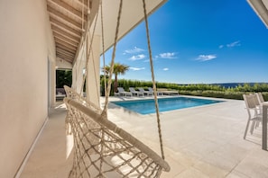 A pool area with a hammock, lounge chairs, and a clear view of the landscape. - Pool Villa Ora in Nature (Marcana)